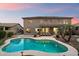 Inviting backyard with a private pool, spacious patio, and a well-maintained two-story home under a vibrant sky at 13634 W San Miguel Ave, Litchfield Park, AZ 85340