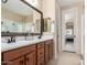 Bathroom featuring double sinks, custom cabinets, and large framed mirror at 1410 W Popcorn Tree Ave, Queen Creek, AZ 85140