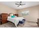 Bright bedroom featuring a ceiling fan, wood-look flooring, and a large window at 1410 W Popcorn Tree Ave, Queen Creek, AZ 85140