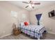 Cozy bedroom featuring light wood flooring, a fan, and natural light at 1410 W Popcorn Tree Ave, Queen Creek, AZ 85140
