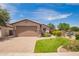 Inviting single-story home featuring a well-manicured lawn, paver driveway, and an attached two-car garage at 1410 W Popcorn Tree Ave, Queen Creek, AZ 85140