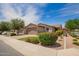 Beautiful single-story home showcasing mature landscaping, colorful flowering shrubs, and a paver driveway at 1410 W Popcorn Tree Ave, Queen Creek, AZ 85140