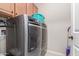 Laundry room features stainless steel washer and dryer and cabinet storage at 1410 W Popcorn Tree Ave, Queen Creek, AZ 85140