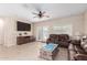 Comfortable living room featuring tile flooring, TV, ceiling fan, and leather sofa at 1410 W Popcorn Tree Ave, Queen Creek, AZ 85140