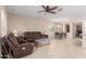 Cozy living room area with tile flooring, comfortable furniture, and a ceiling fan for added comfort at 1410 W Popcorn Tree Ave, Queen Creek, AZ 85140