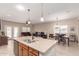 Open-concept living space featuring a kitchen island, dining area, and comfortable seating for entertaining at 1410 W Popcorn Tree Ave, Queen Creek, AZ 85140