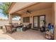 Charming covered patio offering comfortable seating and a ceiling fan at 1410 W Popcorn Tree Ave, Queen Creek, AZ 85140