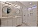 Modern bathroom showcasing dual vanity sinks, walk-in shower with glass door, and elegant lighting fixtures at 17421 N 14Th St, Phoenix, AZ 85022