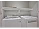 Convenient laundry area equipped with modern washer and dryer units and a storage shelf at 17421 N 14Th St, Phoenix, AZ 85022