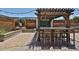 Outdoor patio featuring a wooden pergola, built-in seating, and patterned pavers, perfect for outdoor relaxation at 17421 N 14Th St, Phoenix, AZ 85022