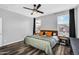 Comfortable main bedroom with a ceiling fan, wood-look floors, and two large windows at 1747 E Grove St, Phoenix, AZ 85040