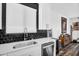 Modern kitchen featuring stainless steel appliances, white cabinetry, black backsplash, and a stainless steel sink at 1747 E Grove St, Phoenix, AZ 85040