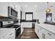 Modern kitchen featuring stainless steel appliances, white cabinetry, black backsplash, and a large island at 1747 E Grove St, Phoenix, AZ 85040