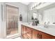 Bathroom with double vanity, wood cabinets, and a large window with a backyard view at 1802 W Isleta Ave, Mesa, AZ 85202