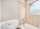 Bright bathroom with a tiled shower and tub combo, featuring neutral tones and a frosted window for natural light at 1802 W Isleta Ave, Mesa, AZ 85202