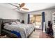 Primary bedroom featuring a ceiling fan, wood floors, and sliding glass doors to the backyard at 1802 W Isleta Ave, Mesa, AZ 85202