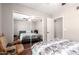 Bedroom featuring hardwood floors, ceiling fan, closet with mirrors, and a rocking chair at 1802 W Isleta Ave, Mesa, AZ 85202