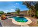Backyard pool with pebble landscaping, secure fencing, and a fun inflatable alligator for summer enjoyment at 1802 W Isleta Ave, Mesa, AZ 85202
