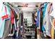 A very full walk-in closet with shelving for shoes and clothes hanging on the racks at 1802 W Isleta Ave, Mesa, AZ 85202