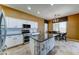 Bright kitchen with stainless steel appliances, white cabinets, and granite countertops with eat in area at 18195 W Marshall Ln, Surprise, AZ 85388
