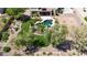 Aerial view of lush backyard featuring pool, spa, artificial turf, fire pit and desert landscaping at 18329 W Montebello Ave, Litchfield Park, AZ 85340