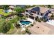 Aerial view showcasing a pool, spa, covered patio, lush landscaping, and solar panels at 18329 W Montebello Ave, Litchfield Park, AZ 85340