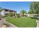 Expansive backyard with artificial turf, palm trees, and lush desert landscaping at 18329 W Montebello Ave, Litchfield Park, AZ 85340