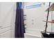 Bright bathroom showcasing a shower/tub combo with a blue shower curtain and handy shelving at 18329 W Montebello Ave, Litchfield Park, AZ 85340