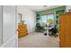 Bedroom with green accent wall, built-in shelves, a work space, and a window overlooking the yard at 18329 W Montebello Ave, Litchfield Park, AZ 85340