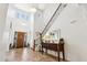 Bright foyer featuring high ceilings, tiled floors, a wooden door, and a staircase with iron railings at 18329 W Montebello Ave, Litchfield Park, AZ 85340
