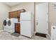 Well-equipped laundry room featuring modern washer, dryer, refrigerator and cabinet storage at 18329 W Montebello Ave, Litchfield Park, AZ 85340