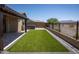 Backyard featuring artificial turf, a spa, and brick pavers, all surrounded by desert landscaping and mountain views at 18493 W Hiddenview Dr, Goodyear, AZ 85338