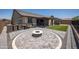 Spacious backyard with artificial turf, brick pavers, a fire pit, outdoor kitchen, and covered patio at 18493 W Hiddenview Dr, Goodyear, AZ 85338