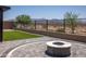 Backyard with artificial turf, a concrete block fence, and a circular brick fire pit with built-in seating at 18493 W Hiddenview Dr, Goodyear, AZ 85338