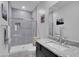 Modern bathroom featuring a glass-enclosed shower, granite counters, a large mirror, and contemporary decor at 18493 W Hiddenview Dr, Goodyear, AZ 85338