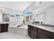Bathroom featuring a soaking tub, and dark wood vanities topped with granite at 18493 W Hiddenview Dr, Goodyear, AZ 85338