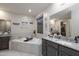 Bright bathroom features a soaking tub, granite counters, and walk-in closet access at 18493 W Hiddenview Dr, Goodyear, AZ 85338