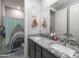 A bathroom with double sinks, granite counters, and playful shark themed shower curtain at 18493 W Hiddenview Dr, Goodyear, AZ 85338