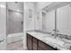 Dual sink bathroom with stone countertops, dark wood cabinets, and a tub shower at 18493 W Hiddenview Dr, Goodyear, AZ 85338