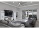 Open living room with fan, TV, and sliding doors leading to the outdoor covered patio at 18493 W Hiddenview Dr, Goodyear, AZ 85338