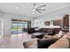 Bright living room featuring a ceiling fan, patio access, and an open layout connecting to the kitchen at 18493 W Hiddenview Dr, Goodyear, AZ 85338
