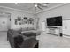 Bright living room with tile flooring, large sectional couch, and flat screen TV at 18493 W Hiddenview Dr, Goodyear, AZ 85338