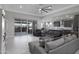 Spacious living room with tile floors, fan, and sliding doors to the covered patio at 18493 W Hiddenview Dr, Goodyear, AZ 85338