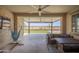 Covered patio space with ceiling fan, seating, and view of the fenced backyard with artificial turf at 18493 W Hiddenview Dr, Goodyear, AZ 85338