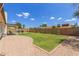 Private backyard featuring a covered patio, lush lawn, and a brick perimeter with space for outdoor activities at 19 W Wickieup Ln, Phoenix, AZ 85027