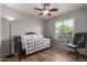 Neutral bedroom featuring wood-look floors, a modern ceiling fan, and a daybed at 19 W Wickieup Ln, Phoenix, AZ 85027