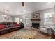 Open-concept living room featuring a charming brick fireplace, a ceiling fan, and stylish wood-look tile floors at 19 W Wickieup Ln, Phoenix, AZ 85027