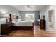 Comfortable bedroom with wood floors, dresser, queen size bed, and bright window overlooking the neighborhood at 19 W Wickieup Ln, Phoenix, AZ 85027