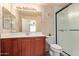 Bathroom with a brown vanity cabinet, framed mirror, modern lighting and a glass-enclosed shower at 2401 E Rio Salado Pkwy # 1192, Tempe, AZ 85288