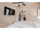 Comfortable bedroom with a ceiling fan, wall-mounted TV, and ensuite bathroom with a view into the vanity area at 2401 E Rio Salado Pkwy # 1192, Tempe, AZ 85288